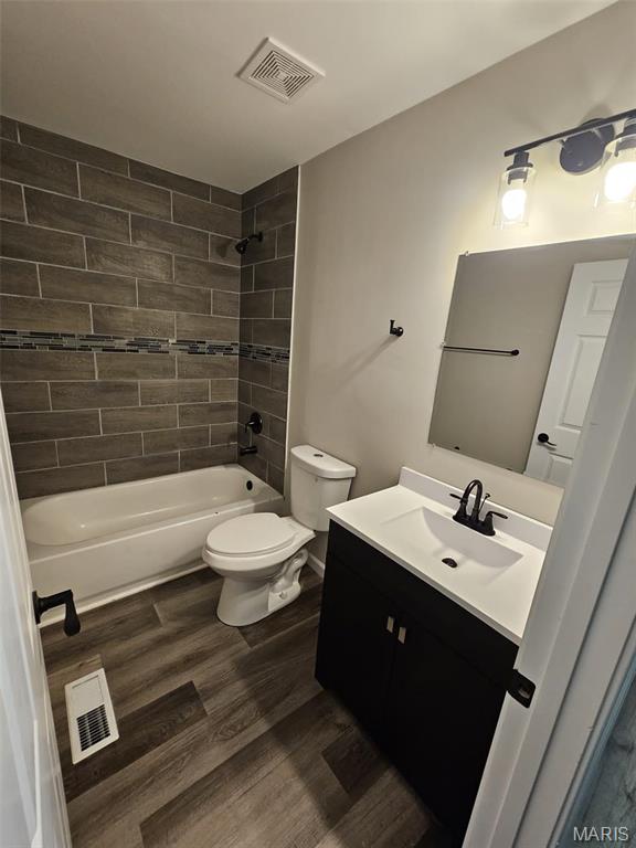 9827 Winkler Dr, Saint Louis, MO 63136 - full bathroom featuring toilet, vanity,  shower combination, and wood finished floors