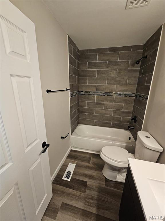 9827 Winkler Dr, Saint Louis, MO 63136 - full bath with toilet, wood finished floors, bathing tub / shower combination, and vanity