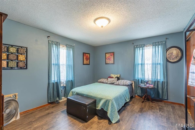 345 Johns Branch Rd, Wappapello, MO 63966 - bedroom featuring wood finished floors, multiple windows, a textured ceiling, and baseboards