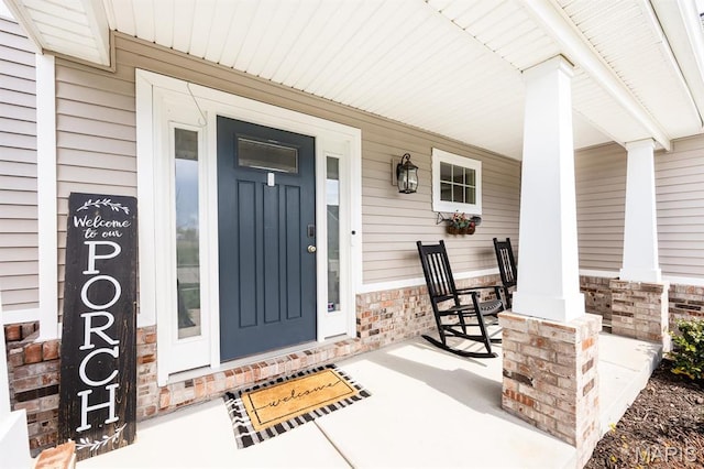 doorway to property with covered porch and stone siding