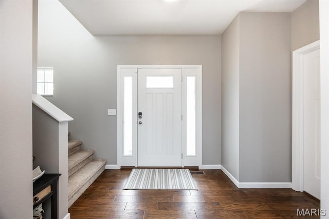 foyer entrance with baseboards, dark wood finished floors, and stairway