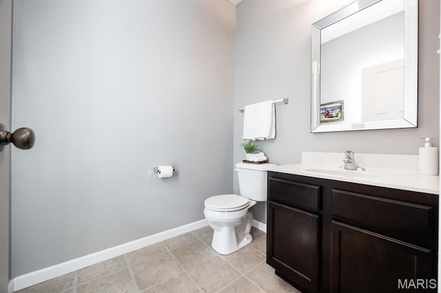 bathroom with baseboards, toilet, and vanity