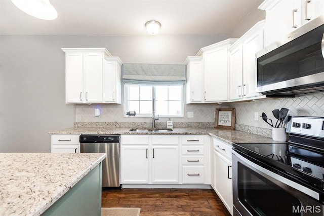 kitchen featuring stainless steel appliances, dark wood-type flooring, white cabinets, and light stone countertops