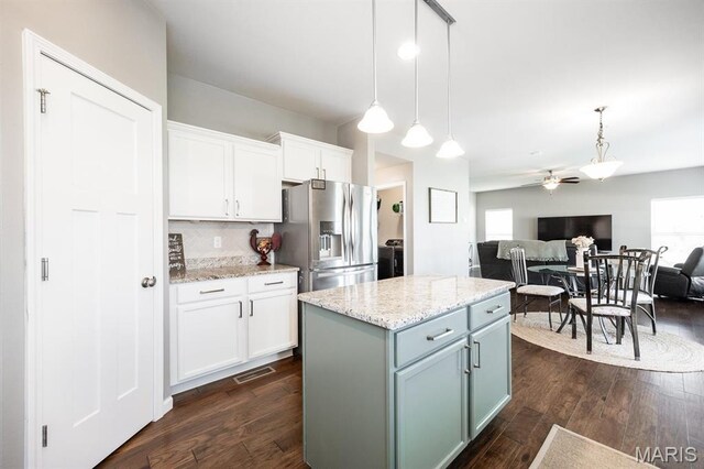 kitchen featuring stainless steel fridge, open floor plan, white cabinetry, ceiling fan, and decorative light fixtures
