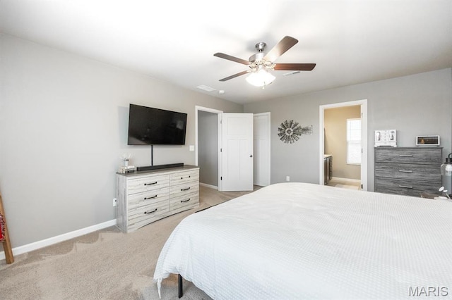 bedroom featuring baseboards, light carpet, ceiling fan, and ensuite bath