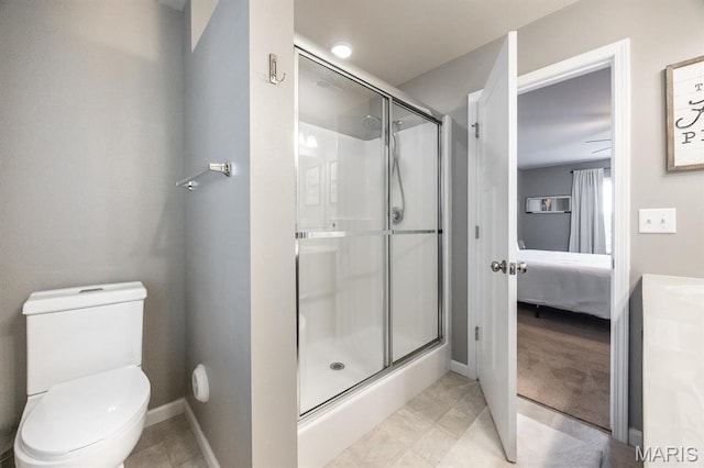 bathroom with a shower stall, ensuite bathroom, baseboards, and toilet