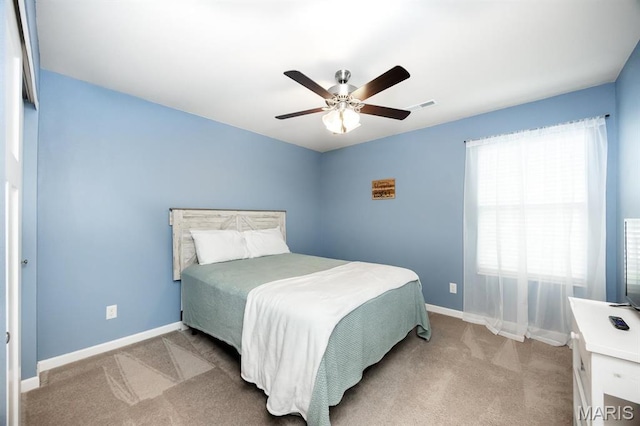 bedroom with light colored carpet, baseboards, and ceiling fan