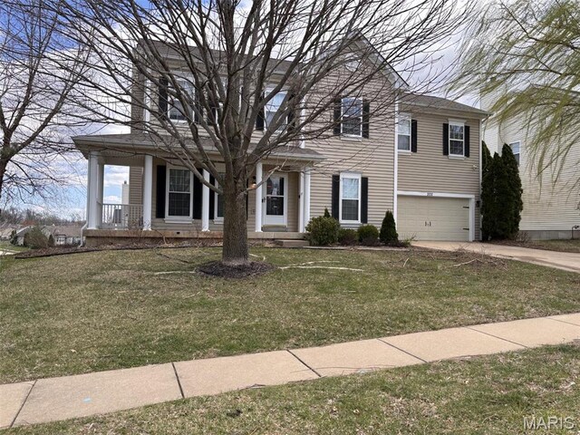 202 Reliance Rd, Foristell, MO 63385 - view of front of house with a garage, a porch, concrete driveway, and a front lawn