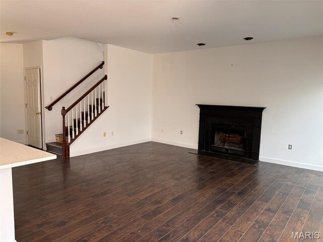 202 Reliance Rd, Foristell, MO 63385 - unfurnished living room with dark wood-type flooring, stairway, a fireplace, and baseboards