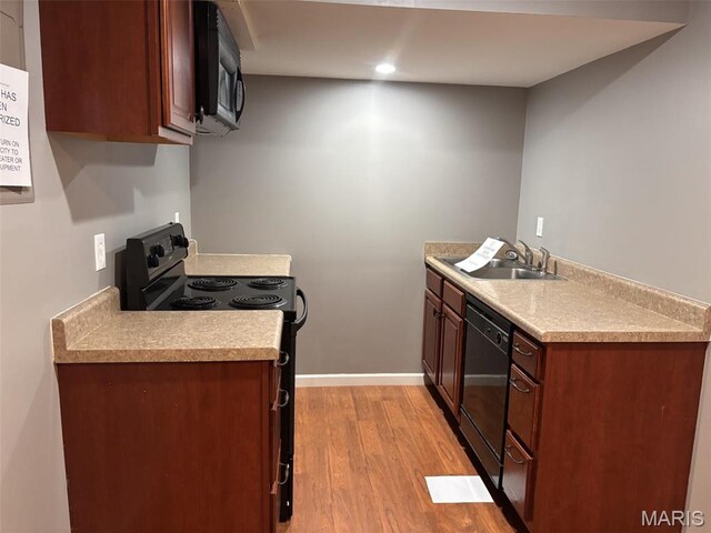 202 Reliance Rd, Foristell, MO 63385 - kitchen with black appliances, a sink, light wood-type flooring, light countertops, and baseboards