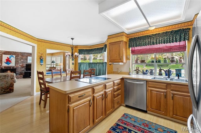 405 Seven Gables Ct, Chesterfield, MO 63017 - kitchen featuring stainless steel appliances, a sink, light wood finished floors, a peninsula, and light countertops