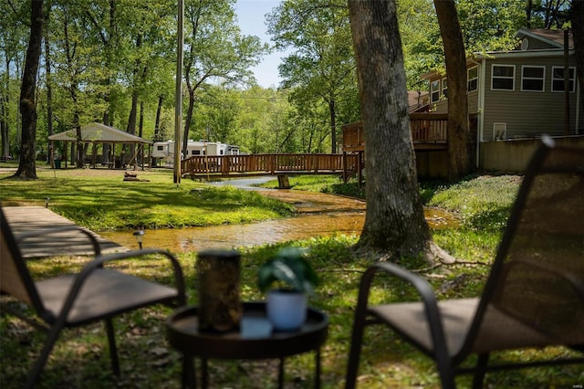 view of community featuring a gazebo, a wooden deck, and a yard
