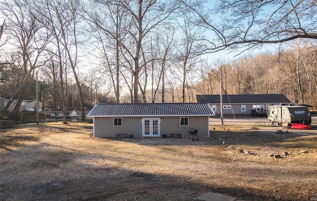 rear view of house with french doors and metal roof