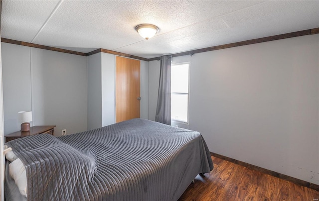bedroom featuring wood finished floors, baseboards, and a textured ceiling