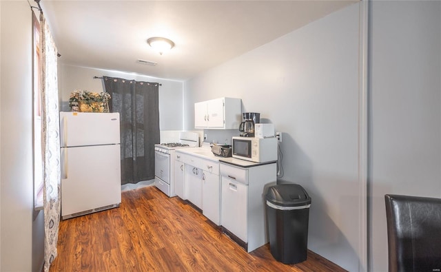 kitchen with white appliances, white cabinetry, and dark wood-style floors
