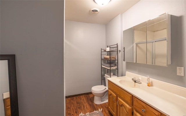 bathroom with wood finished floors, vanity, toilet, and baseboards