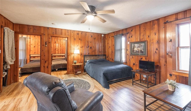 bedroom with wooden walls and light wood-type flooring