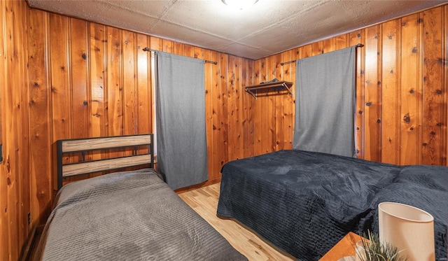 bedroom featuring light wood-type flooring and wood walls