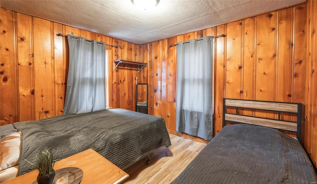 bedroom featuring light wood-style flooring and wood walls