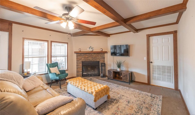 carpeted living area with beam ceiling, ceiling fan, baseboards, a stone fireplace, and coffered ceiling
