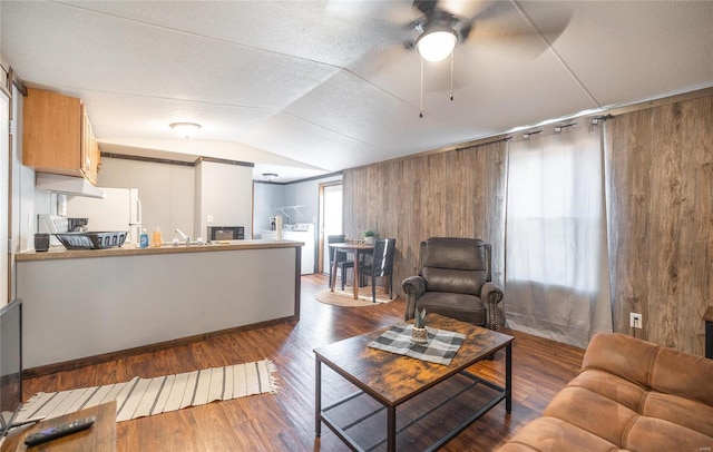 living room featuring a ceiling fan, wood finished floors, wood walls, and lofted ceiling