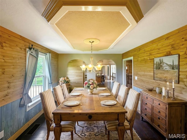 7203 Jakes Pr, Sullivan, MO 63080 - dining area with wood walls, arched walkways, a chandelier, dark wood finished floors, and a raised ceiling