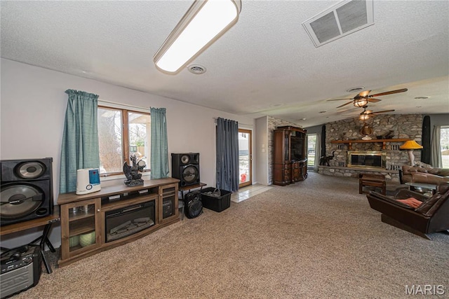 708 E Candy Cane Ln, West Frankfort, IL 62896 - carpeted living area featuring a textured ceiling, a stone fireplace, and a ceiling fan