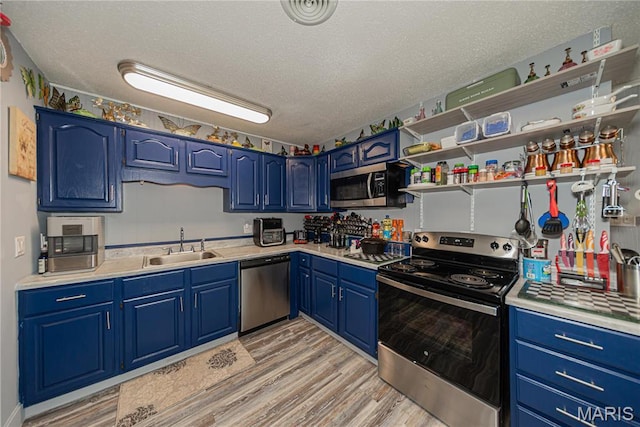 708 E Candy Cane Ln, West Frankfort, IL 62896 - kitchen featuring stainless steel appliances, blue cabinetry, light countertops, a textured ceiling, and light wood finished floors