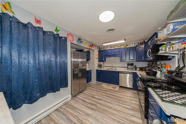 708 E Candy Cane Ln, West Frankfort, IL 62896 - kitchen with appliances with stainless steel finishes, a baseboard heating unit, a textured ceiling, light countertops, and blue cabinetry