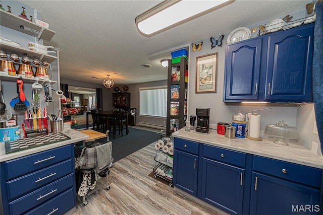 708 E Candy Cane Ln, West Frankfort, IL 62896 - kitchen featuring blue cabinetry, a textured ceiling, light countertops, light wood finished floors, and open shelves
