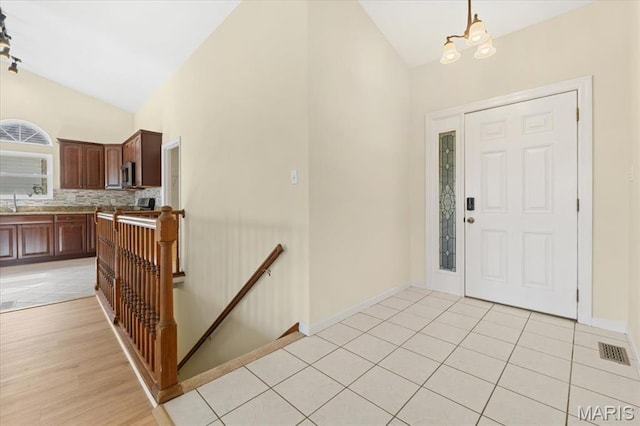 13374 Wintergreen Estates Dr, Fenton, MO 63026 - entryway with vaulted ceiling, a chandelier, and light tile patterned flooring