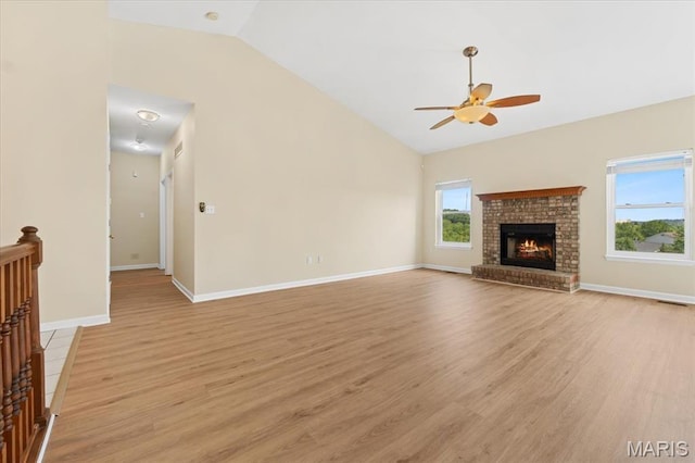 13374 Wintergreen Estates Dr, Fenton, MO 63026 - unfurnished living room with ceiling fan, light wood-style flooring, a brick fireplace, and high vaulted ceiling