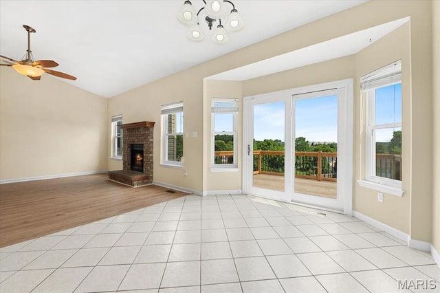 13374 Wintergreen Estates Dr, Fenton, MO 63026 - unfurnished living room with plenty of natural light, vaulted ceiling, a fireplace, ceiling fan, and a chandelier