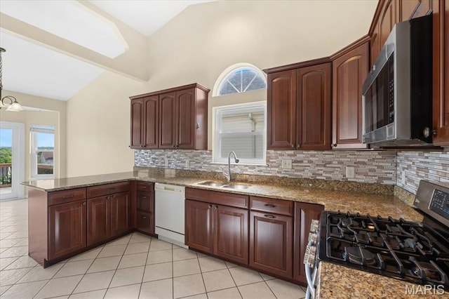 13374 Wintergreen Estates Dr, Fenton, MO 63026 - kitchen with stainless steel appliances, vaulted ceiling, decorative backsplash, light tile patterned flooring, and a peninsula