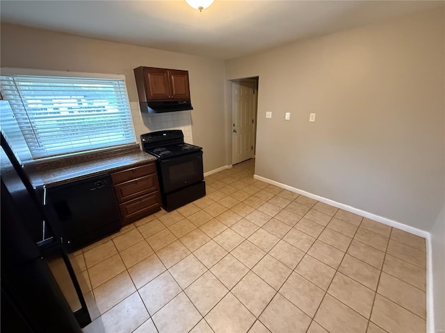 1418 Broadlawns Ln, Saint Louis, MO 63138 - kitchen with black appliances, dark countertops, under cabinet range hood, light tile patterned floors, and baseboards