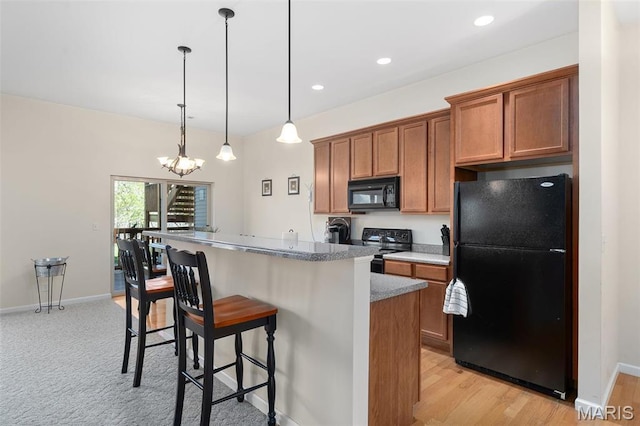 152 Geneva Cove Dr, Innsbrook, MO 63390 - kitchen with black appliances, brown cabinets, a kitchen breakfast bar, a center island, and a chandelier
