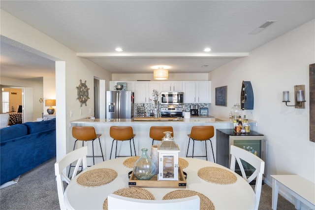 carpeted dining room with recessed lighting