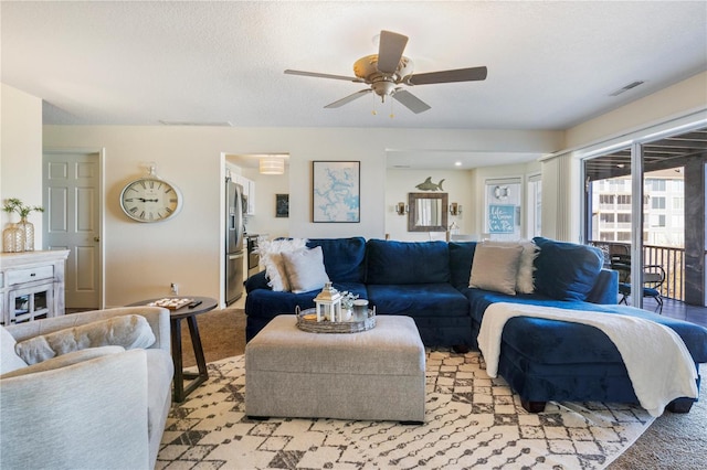 living area with light colored carpet and ceiling fan