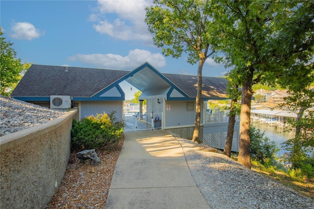 view of front of house featuring a gate, ac unit, and a shingled roof