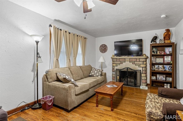 399 Roberts St, Saint Genevieve, MO 63670 - living area with wood finished floors, ceiling fan, a fireplace, and a textured ceiling