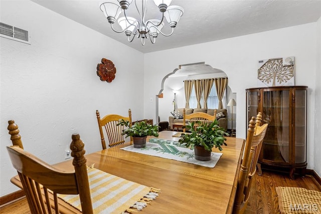 399 Roberts St, Saint Genevieve, MO 63670 - dining room featuring arched walkways, a chandelier, wood finished floors, and baseboards