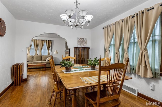 399 Roberts St, Saint Genevieve, MO 63670 - dining space featuring arched walkways, baseboards, a chandelier, plenty of natural light, and a textured ceiling