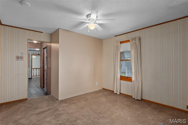 204 E 3rd N St, Mount Olive, IL 62069 - carpeted empty room featuring a ceiling fan, wallpapered walls, a textured ceiling, a smoke detector, and crown molding