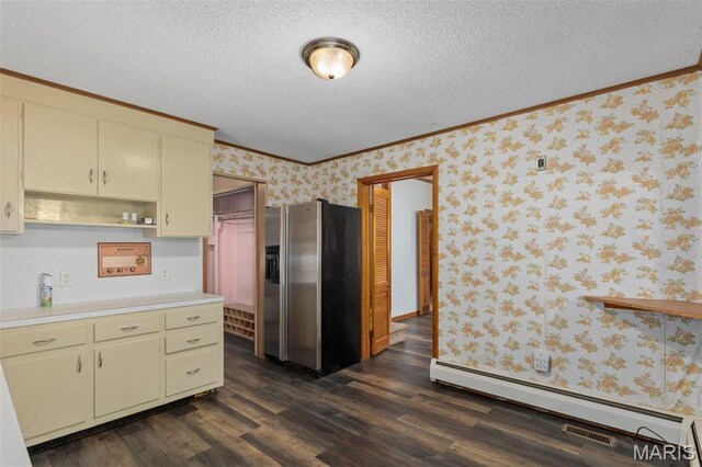 204 E 3rd N St, Mount Olive, IL 62069 - kitchen with stainless steel fridge with ice dispenser, baseboard heating, wallpapered walls, light countertops, and cream cabinetry