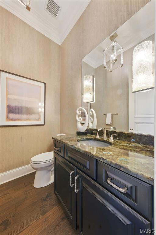 1212 Dolman St, Saint Louis, MO 63104 - bathroom featuring crown molding, wood finished floors, vanity, toilet, and baseboards