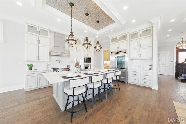 1212 Dolman St, Saint Louis, MO 63104 - kitchen with built in appliances, custom range hood, a tray ceiling, a kitchen bar, and tasteful backsplash