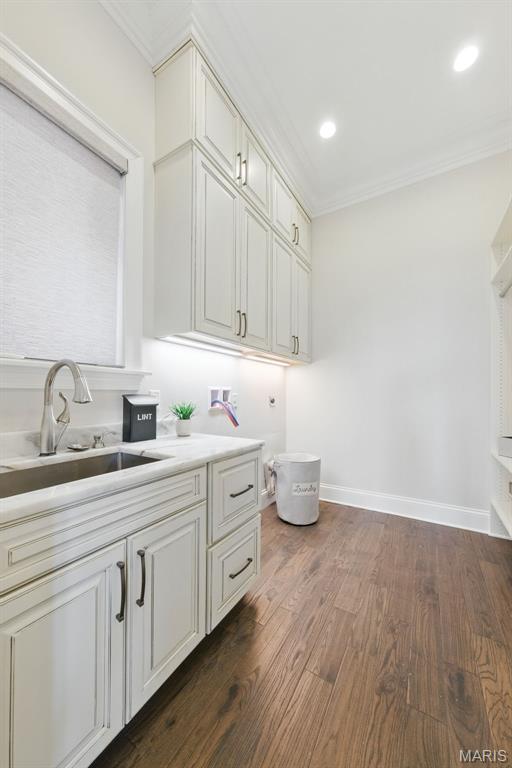 1212 Dolman St, Saint Louis, MO 63104 - washroom with cabinet space, hookup for a washing machine, ornamental molding, dark wood-style flooring, and baseboards