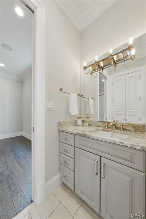 1212 Dolman St, Saint Louis, MO 63104 - bathroom with crown molding, vanity, a chandelier, baseboards, and wood finished floors