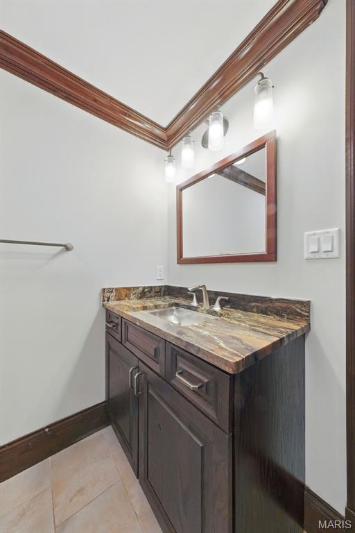 1212 Dolman St, Saint Louis, MO 63104 - bathroom featuring crown molding, vanity, baseboards, and tile patterned floors