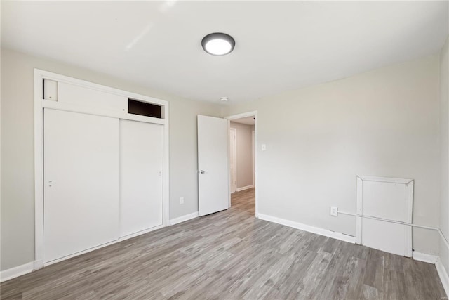 7921 Glenside Pl, Saint Louis, MO 63130 - unfurnished bedroom with wood finished floors, a closet, and baseboards